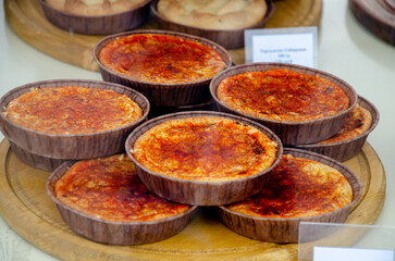 Delicious and fresh desserts in the form of tartlets on display behind glass