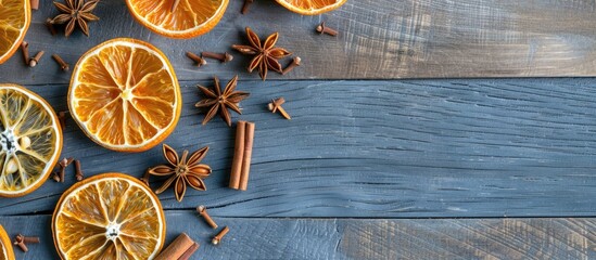 Poster - Flat lay composition on a grey wooden table featuring dry orange slices anise stars and cinnamon sticks with available copy space image