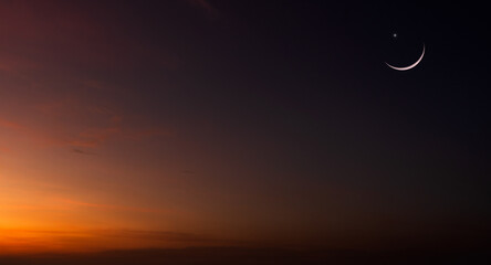 Crescent moon on Dusk sky clouds after sun down on twilight sky background, Symbol Religion of Islamic well free space for text Arabic Ramadan Kareem, Eid Al Adha, Eid Al Fitr, Mubarak 