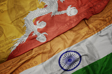 Wall Mural - waving colorful flag of india and national flag of bhutan on the dollar money background. finance concept.