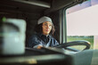 © Marko Geber - Mature female truck driver at the wheel on the road