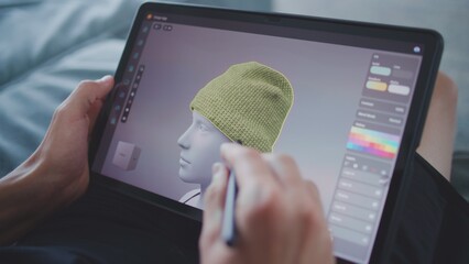 Fototapete - Focused teenager with digital pencil and tablet in hands sits in room, draws 3d model. Boy creates new game character and animation using 3d modeling program. Game design and development. Close up.