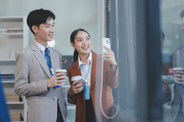 Wall Mural - Successful young business people talking, working together in front of modern business building