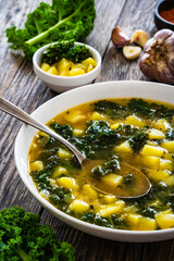 Sticker - Portuguese green soup - Caldo Verde.  Potato and kale soup served in white bowl on wooden table