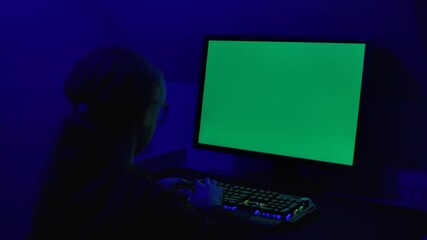 Girl of Green Screen Display PC at Desk in Home at Night. Desktop PC Monitor With Green Mockup, Chroma Key, Working. Person Teenager Programer Typing Codes Mockup Computer. Software Development.