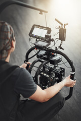 Photographer, camera and filming with stabilizing rig on set for photography, media and magazine. Cameraman, focus and person backstage for shooting, production and equipment as director with lens