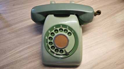 Vintage Green Rotary Dial Telephone or phone on Wooden Surface in Classic Design