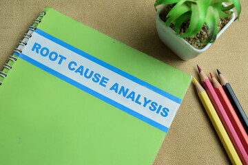 Concept of Root Cause Analysis write on book isolated on Wooden Table.