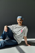 © LIGHTFIELD STUDIOS - A woman wearing a pink ribbon sits in casual attire, showcasing her support for breast cancer awareness.