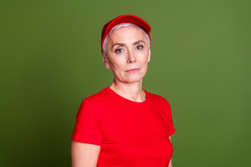 Sticker - Photo of attractive mature woman professional delivery employee look camera wear red uniform workwear isolated on khaki color background