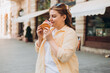 © mdyn - Beautiful overweight brunette 30s girl posing on the street, she has big croissant meal in hands. Unhealthy fattening food,high-calorie snack, eating on the go, take-out meals.