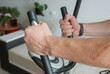 © Ruslan - Male hands on a home exercise machine, home sports concept.
