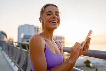 Wall Mural - attractive young woman doing sports in the morning using smartphone