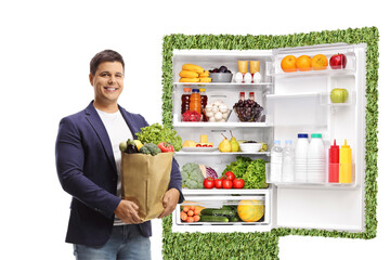 Canvas Print - Young man with a grocery bag and eco friendly fridge