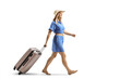© Ljupco Smokovski - Full length profile shot of a woman in a blue dress and straw hat walking and pulling a suitcase