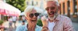 © Dalibor - A older man and woman are sitting on a bench eating ice cream.