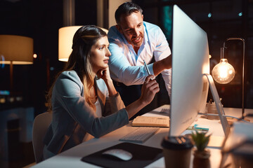 Leinwandbilder - Night, teaching or business people on computer for coaching advice for teamwork, helping or technology. Learning software, research and IT technician talking to woman for feedback or project review