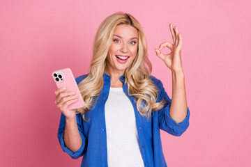 Wall Mural - Photo of shiny attractive lady dressed blue jacket communicating modern device showing okey sign isolated pink color background