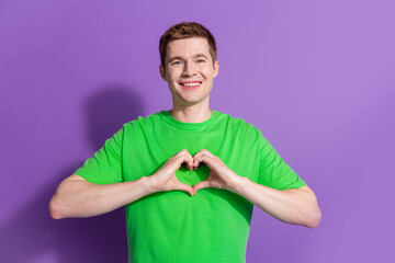 Photo of nice young man show heart symbol wear t-shirt isolated on violet color background