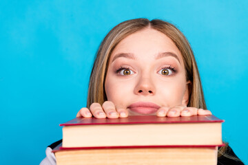 Poster - Close up portrait of lovely clever funny girl wear stylish clothes peek out book materials isolated on blue color background