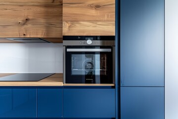 Modern kitchen with white and blue cabinets, built-in oven, and wooden accents