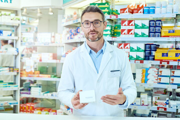 Poster - Man, portrait and pharmacist with box for symptoms, dosage or side effects of pharmaceutical product at pharmacy. Male person or medical employee explaining information on drugs at dispensary store