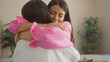 © Krakenimages.com - Two women, possibly sisters or friends, share a heartfelt embrace indoors in a cozy living room, showcasing their emotional bond and connection.