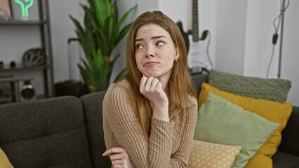 Canvas Print - Pensive young caucasian woman in a cozy living room with modern decor