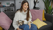 © Krakenimages.com - A cheerful woman cuddles a biewer terrier in a cozy, modern living room.