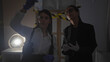 © Krakenimages.com - Two women investigators analyze evidence in a dimly lit indoor crime scene.