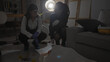 © Krakenimages.com - Two women detectives analyze a crime scene indoors with evidence and a body outline, portraying investigation work.