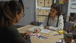 © Krakenimages.com - Two women, one possibly a detective, examine evidence and documents in an indoor office setting, suggesting an investigative scene.
