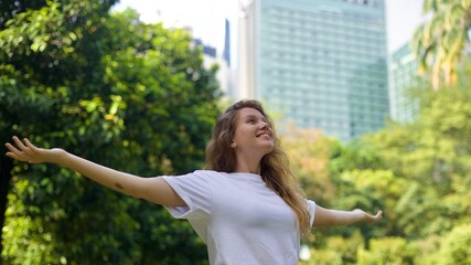 Wall Mural - portrait of a young beautiful woman in the park enjoying the warm weather in spring or summer