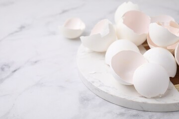 Wall Mural - Broken eggshells on light marble table, closeup. Space for text