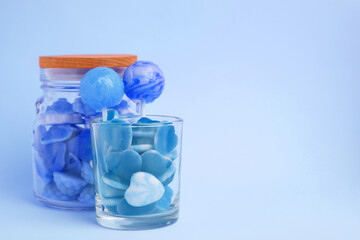 Canvas Print - Many bright candies in glass jars on light blue background. Space for text