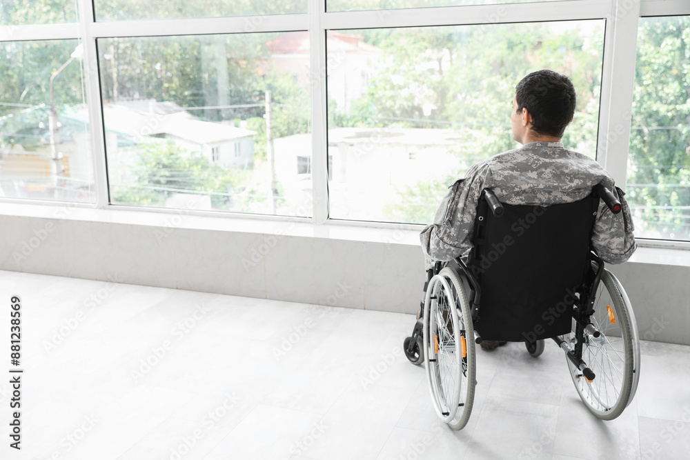 Young soldier in wheelchair at home, back view