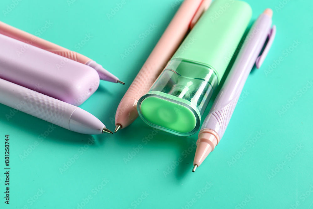 Colorful pens and markers on turquoise background
