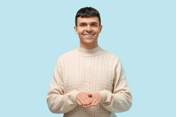 Wall Mural - Young deaf mute man using sign language on blue background