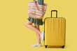 © Pixel-Shot - Young woman with suitcase and bag on yellow background