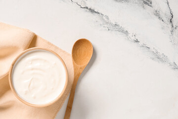 Wall Mural - Wooden bowl of tasty yogurt on white background