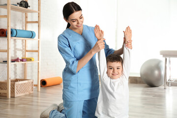 Wall Mural - Orthopedist working with little boy in hospital gym