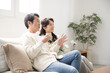 © kapinon - リビングでくつろぐ50代の夫婦の全身　話す会話するカップルの横顔の全身