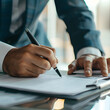 © watcharee - Close-up of a business professional signing a document. The image highlights the importance of paperwork and official agreements in business.