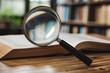 © Emanuel - Magnifying glass and an open book on a desk, representing learning, research, or searching for information