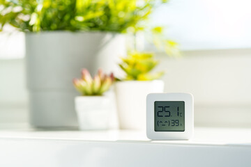 White Digital Thermometer Displaying Room Temperature and Humidity