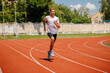 © st.kolesnikov - Young male athlete running on a track