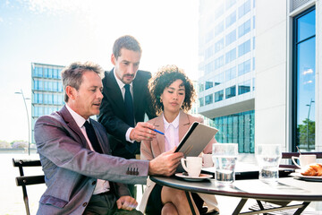 Multiracial group of business people bonding outdoors - International business corporate team wearing elegant suit meeting in a business park