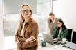 © Ilona - Testimonial portrait of a businesswoman in the office with colleagues.