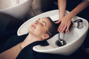 Wall Mural - Woman, salon and basin for washing hair, client and eyes closed or applying treatment with praying hands technique. Professional, hairdresser and haircare with customer, pamper and relaxing service