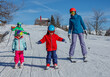 © Sergey Novikov - Mother with two little kids slide down enjoy mountain skiing